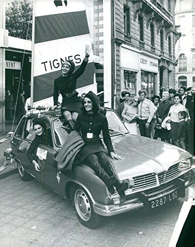 תצלום וינטג 'של דגמים בבגדי סילווי ורטן היושבים במכונית ובמכונית.
